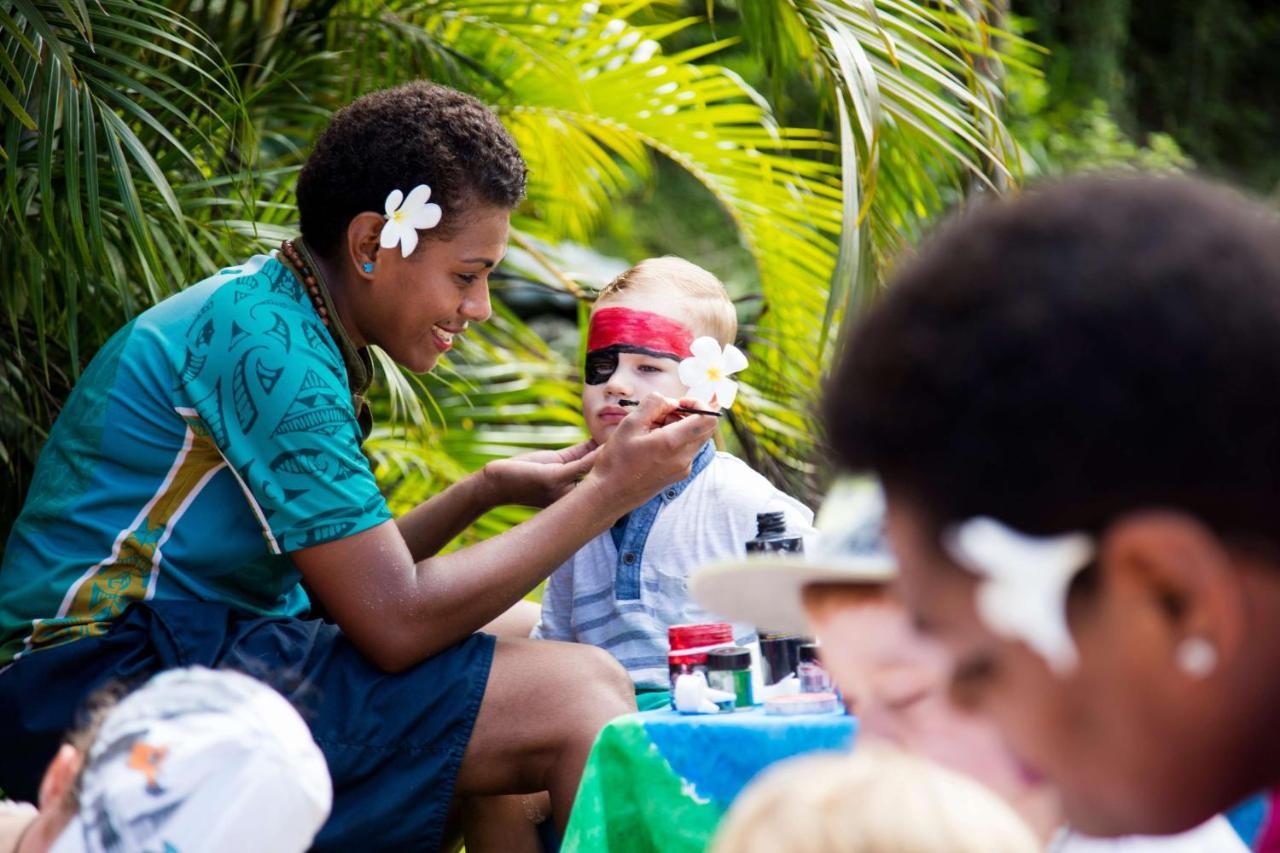 أوتريغر فيجي بيتش ريزورت كوروتوغو المظهر الخارجي الصورة A young woman from the Cook Islands applying titi muka to a child's face